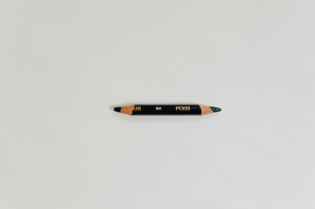 A short, double-sharpened black pencil with worn tips on both ends.
