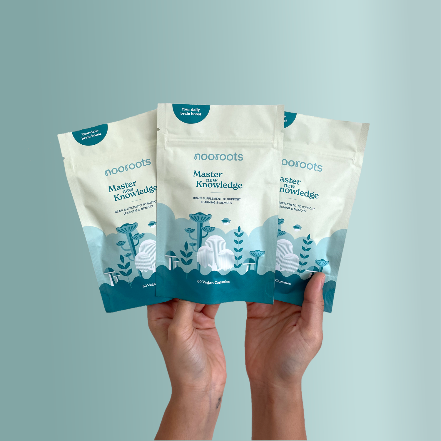 Lady Holding 3 Pouches of Nooroots Learning & Memory formula side by ide