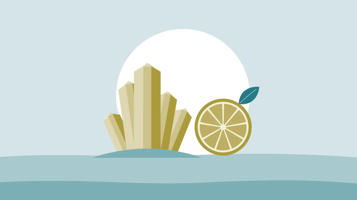 Golden magnesium crystals beside half a lemon on a pale teal background