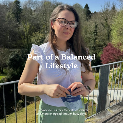 Woman opening a Nooroots supplement pouch outdoors as part of a balanced lifestyle.