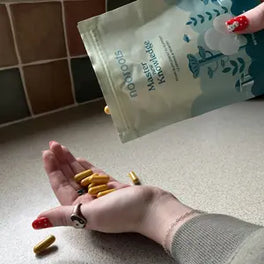 Yellow capsules poured from a Learning & Memory pouch into a hand