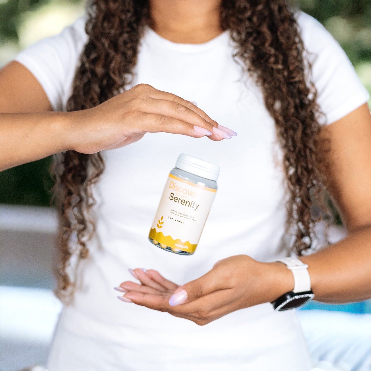 a lady dropping a bottle of nooroots mood nootropic supplement between her hands