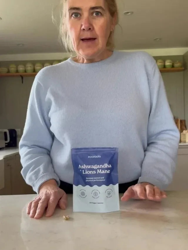 Justine at her kitchen counter with a pouch of Ashwagandha & Lion's Mane