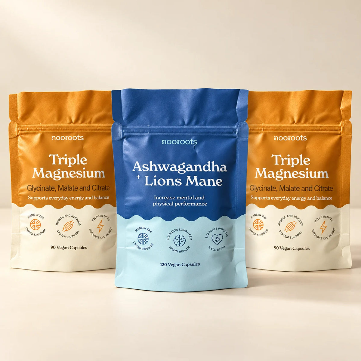 Ashwagandha + Lion's Mane pouch between two Triple Magnesium pouches on a warm cream studio background
